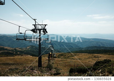 Ski lift chairs on Stara Planina mountain with panoramic view of green hills and valleys. Serbia country in summer season 130835028