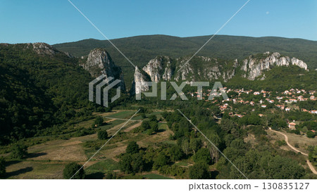 Aerial view of Jerma Canyon in Serbia with a small village surrounded by rocky cliffs and green forest Aerial view of Jerma Canyon in Serbia with a small village surrounded by rocky cliffs and green forest 130835127