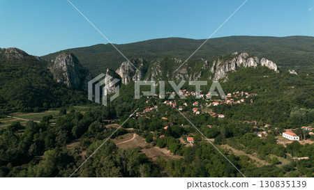 Aerial view of Jerma Canyon in Serbia with a small village surrounded by rocky cliffs and green forest Aerial view of Jerma Canyon in Serbia with a small village surrounded by rocky cliffs and green forest 130835139