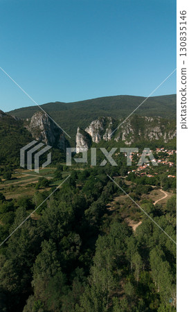 Aerial view of Jerma Canyon in Serbia with a small village surrounded by rocky cliffs and green forest Aerial view of Jerma Canyon in Serbia with a small village surrounded by rocky cliffs and green forest 130835146