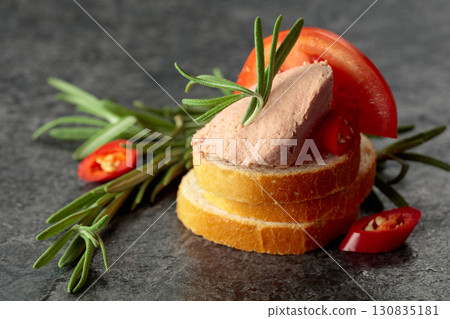 Bread slices with pate, tomato, red pepper, and rosemary. Bread slices with pate, tomato, red pepper, and rosemary. 130835181