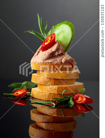 Bread slices with pate, cucumber, red pepper, and rosemary. Bread slices with pate, cucumber, red pepper, and rosemary. 130835183