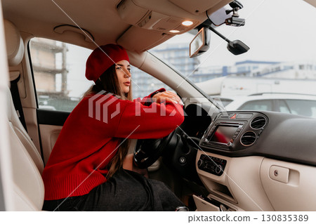 Woman, driving, car. Stylish female driver thoughtfully looking out from modern vehicle. Woman, driving, car. Stylish female driver thoughtfully looking out from modern vehicle. 130835389
