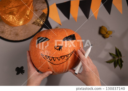 Drawing a Jack O'lantern Face on a Pumpkin for Halloween at Home Drawing a Jack O'lantern Face on a Pumpkin for Halloween at Home 130837140