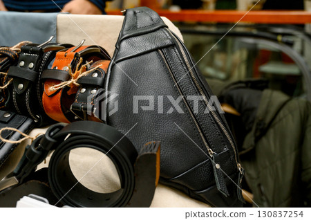 handcrafted leather goods, including notebooks, wallets, and a belt 130837254