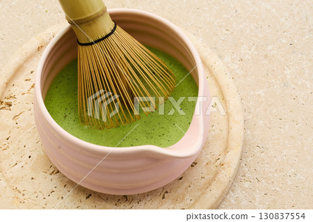 Matcha Tea Preparation. A bamboo whisk in a bowl of frothy matcha tea Matcha Tea Preparation. A bamboo whisk in a bowl of frothy matcha tea 130837554