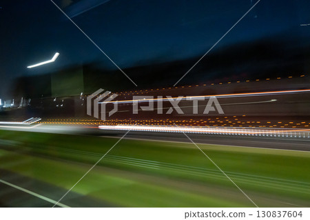 Light trails of a moving vehicle at night on the road Light trails of a moving vehicle at night on the road 130837604