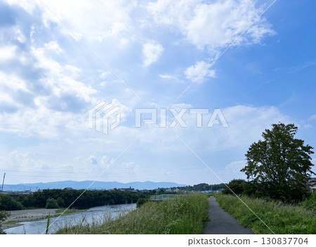 在陽光明媚的夏日裡沿著河岸散步 130837704