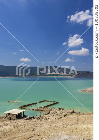Tourists enjoying the turquoise water of the Yesa reservoir in Sigues, Spain, with ruins emerging from the water due to drought 130838302