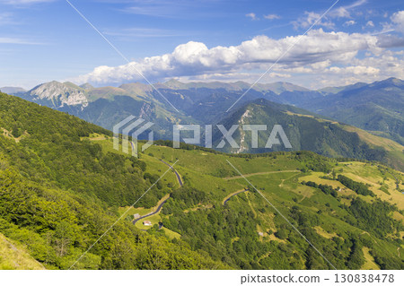 Winding road crossing lush green valley in the Pyrenees mountains, France Winding road crossing lush green valley in the Pyrenees mountains, France 130838478