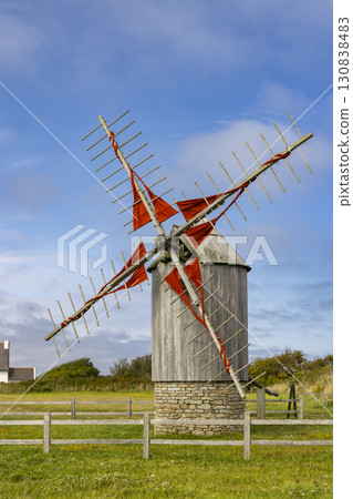 Old wooden windmill with red sails standing in Cleden Cap Sizun, Brittany, France 130838483