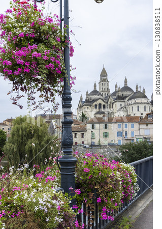 Saint Front Cathedral rising above Perigueux cityscape with colorful flowers decorating Pont des Barris in France 130838511