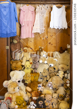 Many teddy bears filling a wooden wardrobe with hanging vintage clothes in Jaromerice nad Rokytnou, Czechia 130838548