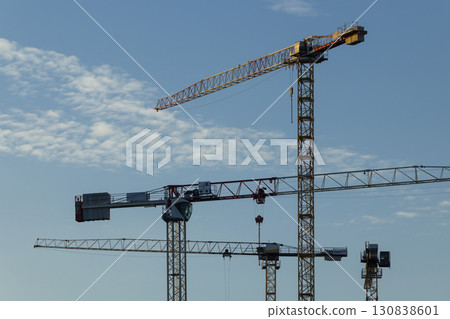 Construction cranes dominating Prague skyline under blue sky Construction cranes dominating Prague skyline under blue sky 130838601