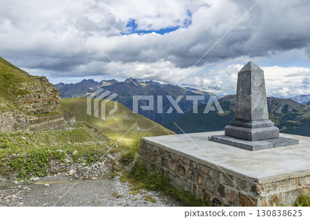 Stone monument overlooking winding mountain road in the Maritime Alps, France 130838625