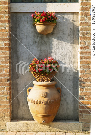 Terracotta vases with flowers decorating a wall in Pienza, Tuscany 130838634