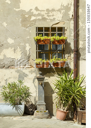 Flowerpots hanging from a barred window and a drinking fountain in Cerreto Guidi, Tuscany Flowerpots hanging from a barred window and a drinking fountain in Cerreto Guidi, Tuscany 130838647