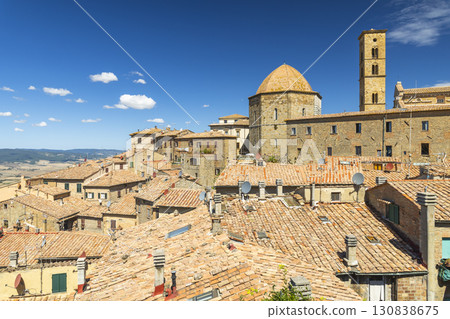 Volterra medieval skyline with tiled roofs and church under blue summer sky 130838675