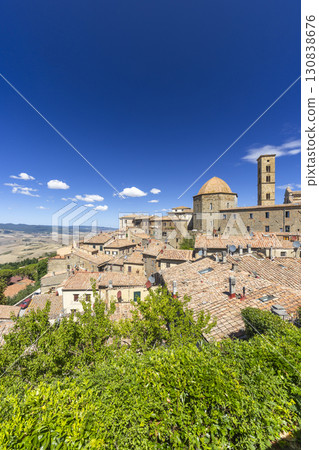 Volterra medieval skyline dominating Tuscany landscape under blue sky 130838676