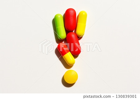 Colorful pills arranged in the shape of an exclamation mark on white background. Concept of surprise, medicine, and health 130839301