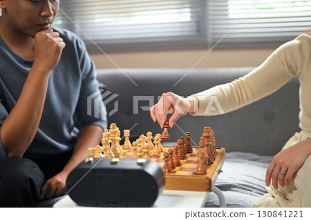 Couple enjoying a strategic chess game together at home Couple enjoying a strategic chess game together at home 130841221