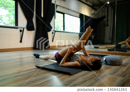 Wellness and mindfulness concept with woman practicing yoga indoors peacefully 130841263