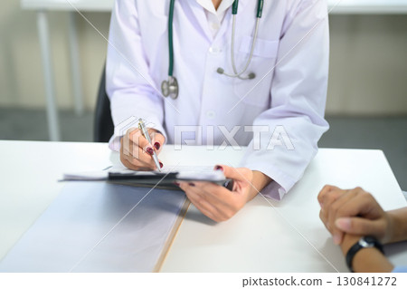 Close up of doctor writing notes on a clipboard during patient consultation Close up of doctor writing notes on a clipboard during patient consultation 130841272