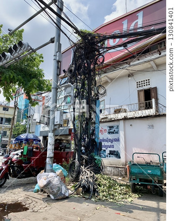 A unique Southeast Asian landscape photo of the intricately tangled electric wires and poles seen on the streets of Phnom Penh, Cambodia 130841401