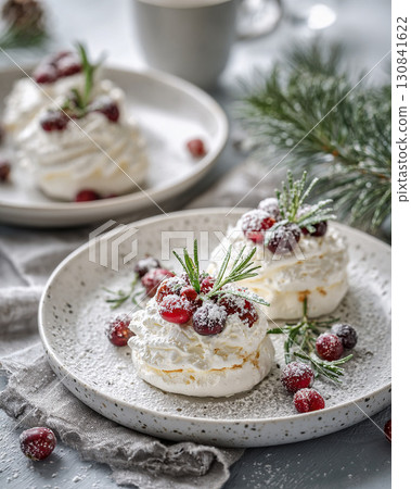 Meringue dessert garnished with red cranberries and fresh rosemary sprigs 130841622