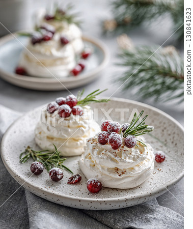 Meringue dessert garnished with red cranberries and fresh rosemary sprigs 130841623