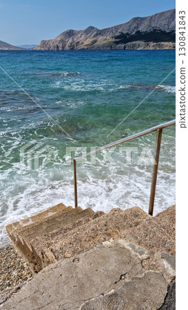 Stone steps descending into the sea 130841843