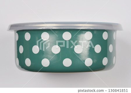 Green enameled bowl with a white polka dots 130841851