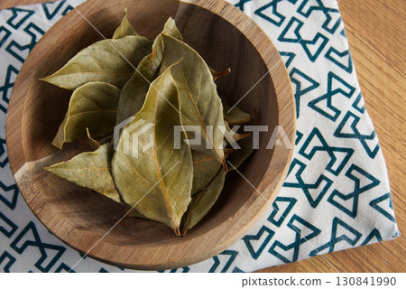 Dried bay leaves in a wooden bowl on the table Dried bay leaves in a wooden bowl on the table 130841990