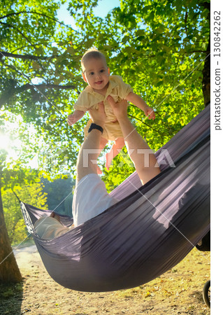 Parent and Baby Enjoying Hammock Time Outdoors Parent and Baby Enjoying Hammock Time Outdoors 130842262