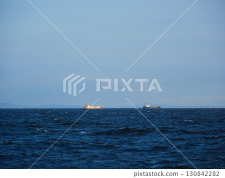 Summer evening scenery of Tokyo Bay's sea surface, the moon in the sky, and a cargo ship 130842282