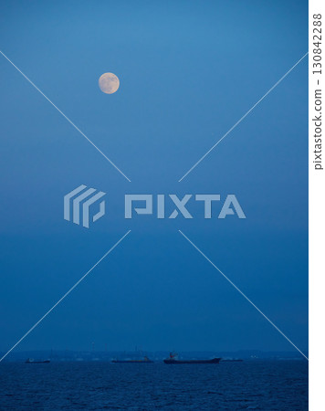 東京灣的海面、天空的月亮和一艘貨船的夏日傍晚景色 130842288
