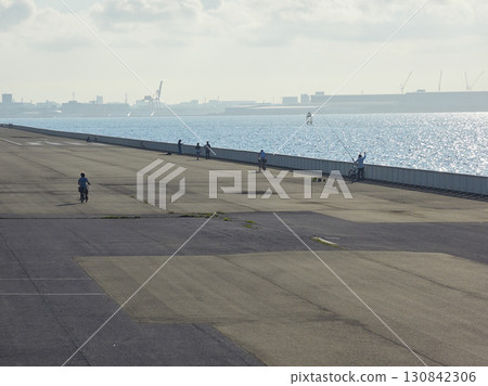 People walking and fishing on the embankment of Shin-Urayasu Park in summer 130842306