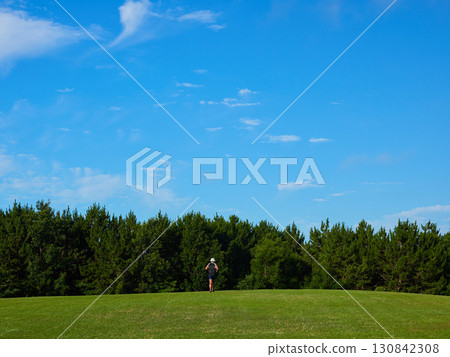 A man running on the grass in a summer park 130842308
