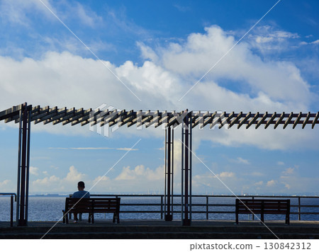 A man sitting on a bench in the rest area of Shin-Urayasu Park in summer 130842312