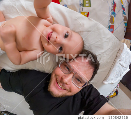 Father and Baby Smiling on Bed Father and Baby Smiling on Bed 130842316
