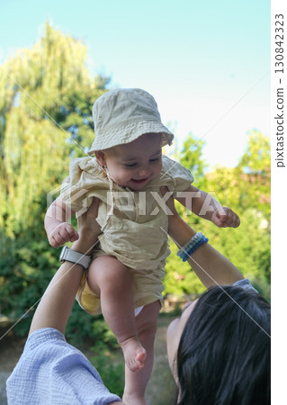 Joyful Baby Lifted in the Air Outdoors Joyful Baby Lifted in the Air Outdoors 130842323