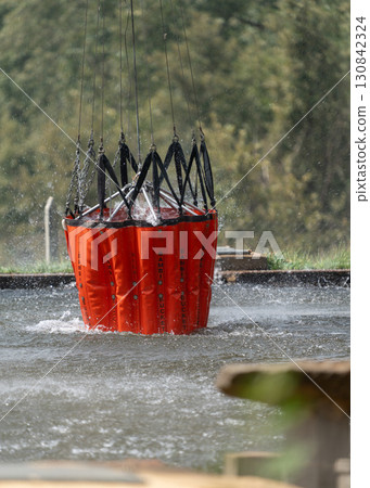 Firefighting Water Bucket Dips into River Scene Firefighting Water Bucket Dips into River Scene 130842324
