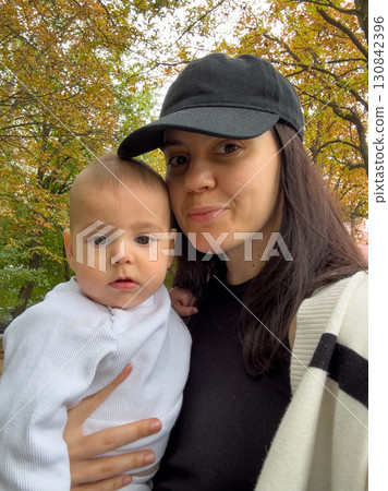 Mother Kissing Baby in Autumn Park Mother Kissing Baby in Autumn Park 130842396