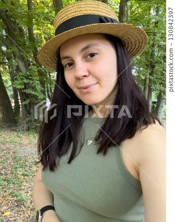 Woman in Straw Hat Smiling in Forest Woman in Straw Hat Smiling in Forest 130842397
