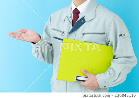 一位身穿工作服的中年男性商人,手裡拿著活頁夾 一位身穿工作服的中年男性商人,手裡拿著活頁夾 130843110