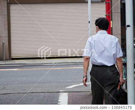 Male office worker walking to work in a summer city shopping district Male office worker walking to work in a summer city shopping district 130843178