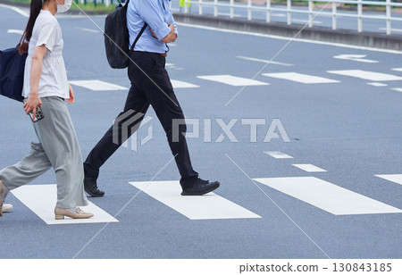 Commuters crossing a crosswalk in an urban street on a summer morning Commuters crossing a crosswalk in an urban street on a summer morning 130843185