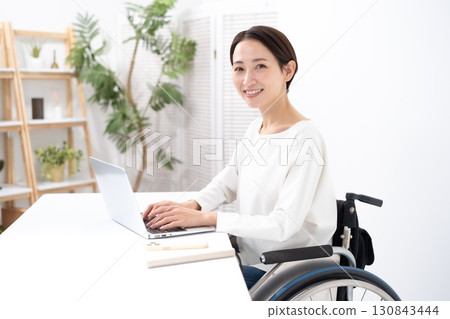 Woman in wheelchair, computer Woman in wheelchair, computer 130843444
