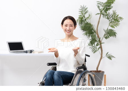 坐在輪椅上在家工作的女人揮舞著雙手 130843460