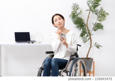 坐在輪椅上在家工作的婦女擔心 130843472